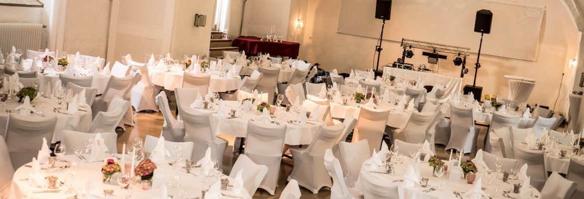 Hochzeit im Kanonsaal der Wülzburg. Hochzeitsdekoration - Weiße Tische, Kerzen und Blumen.